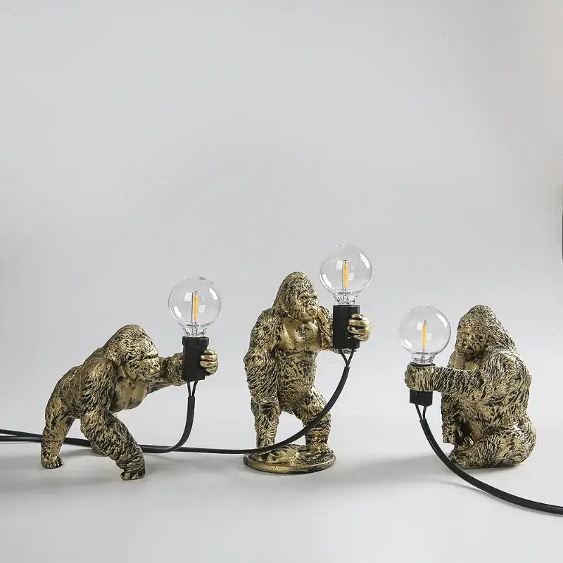 Three golden resin gorilla figurines holding clear edison bulb night lights for decorbites gorilla night bedroom use