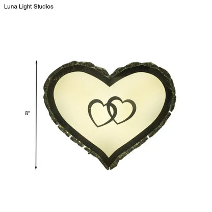 Modern black heart crystal shade wall sconce with textured dark frame and interlocking black heart design on cream light