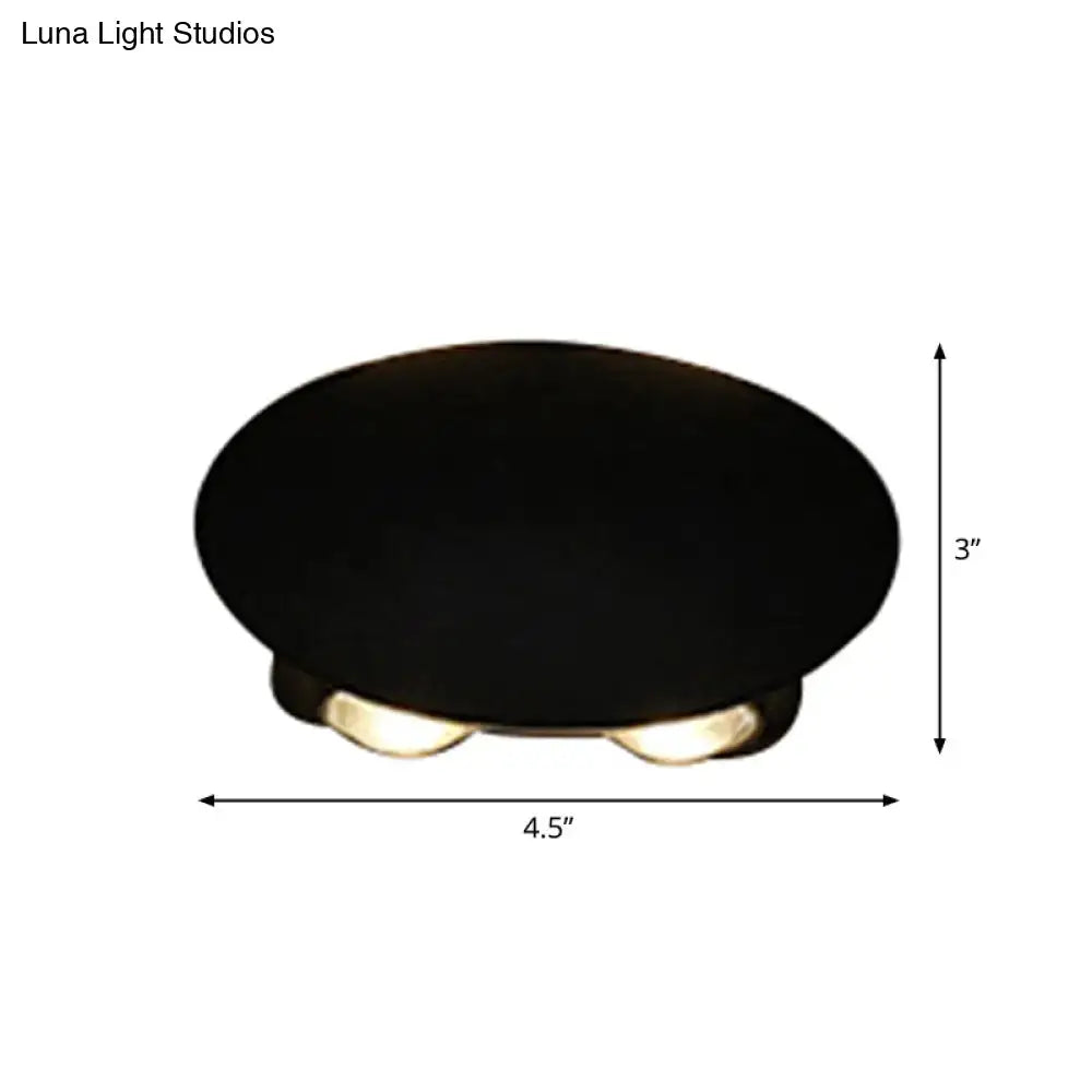 Modern black hexagonal wall washer sconce with black oval ceiling light and three warm-toned led bulbs for hallway lighting