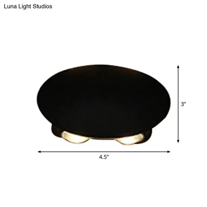 Modern black hexagonal wall washer sconce with black oval ceiling light and three warm-toned led bulbs for hallway lighting