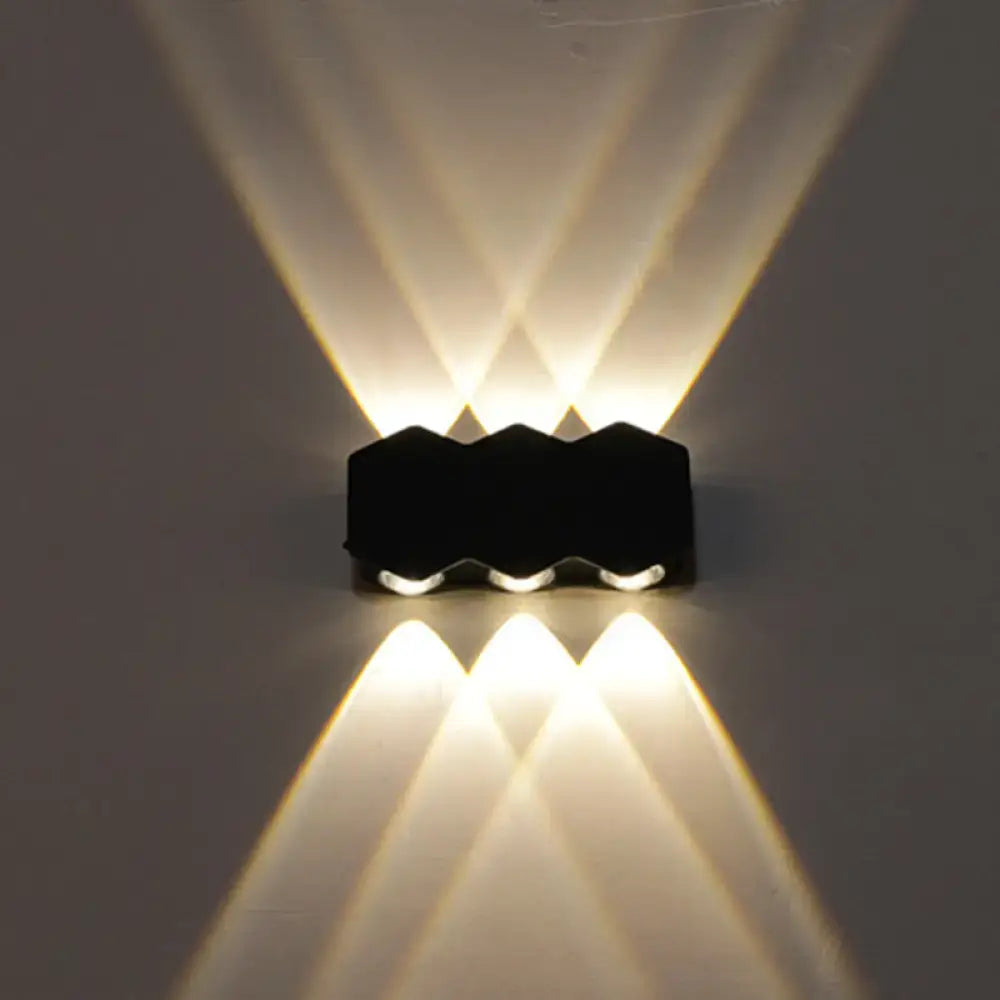 Modern black hexagonal led wall washer sconce with three angled beams of warm white light for hallway lighting
