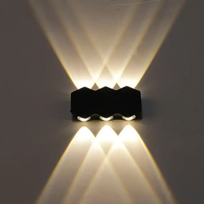 Modern black hexagonal led wall washer sconce with three angled beams of warm white light for hallway lighting