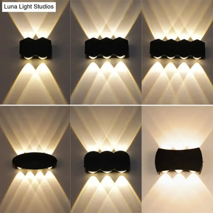 Modern black hexagonal led wall washer sconce with three warm white led lights casting geometric patterns