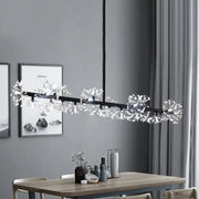 Modern black island pendant light with crystal dandelion clusters hanging above a dining room table
