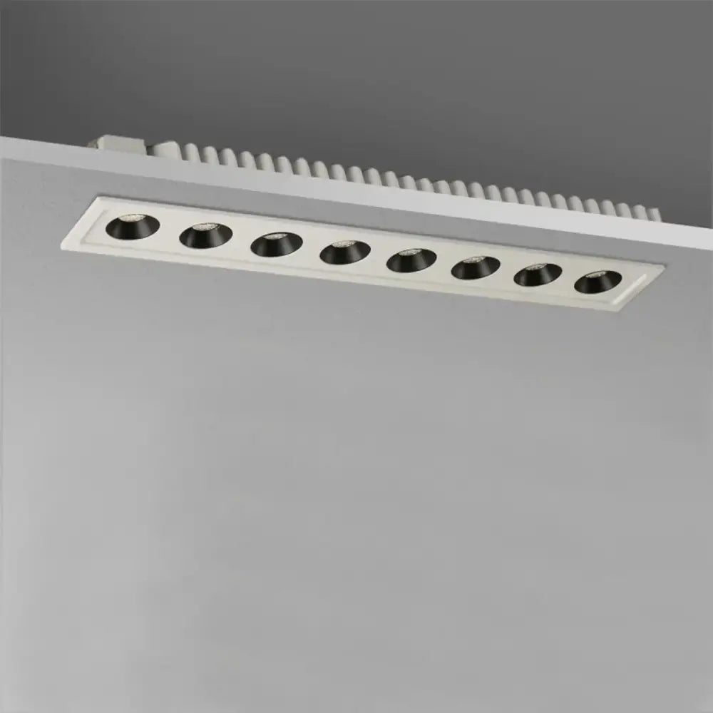 Modern black led grille downlight with six black circular led bulbs in a white rectangular recessed ceiling fixture