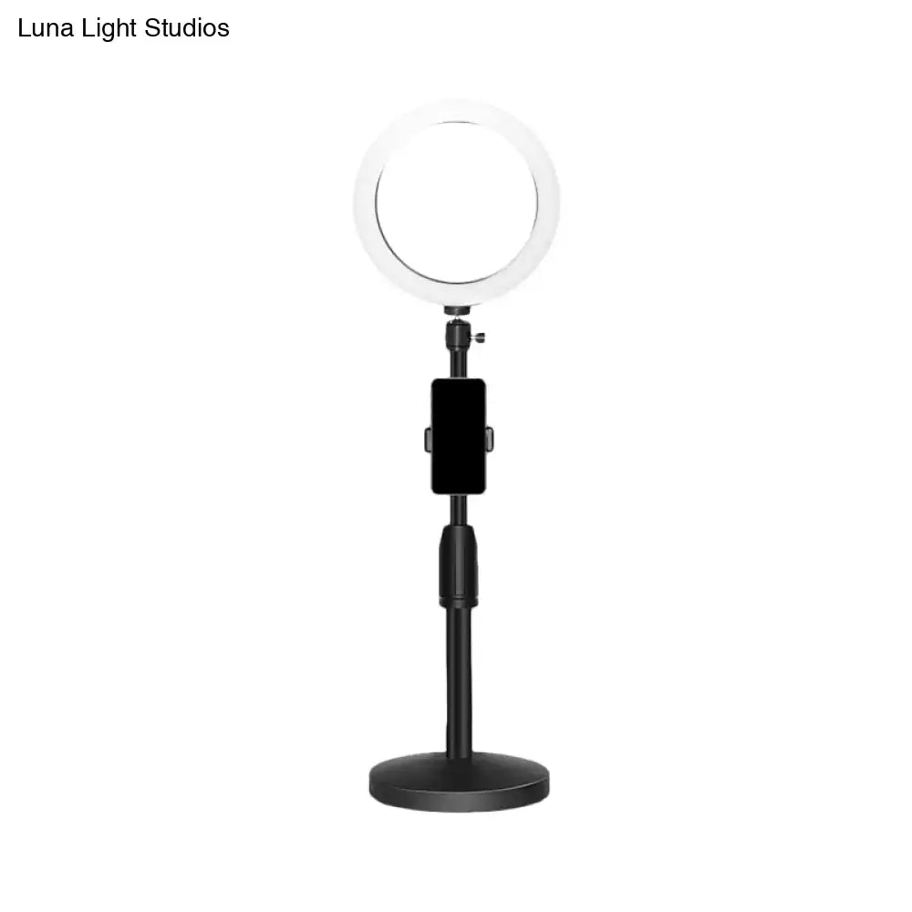 Modern black led ring flash light with phone holder on a stand designed as a bedroom wall light and flash light