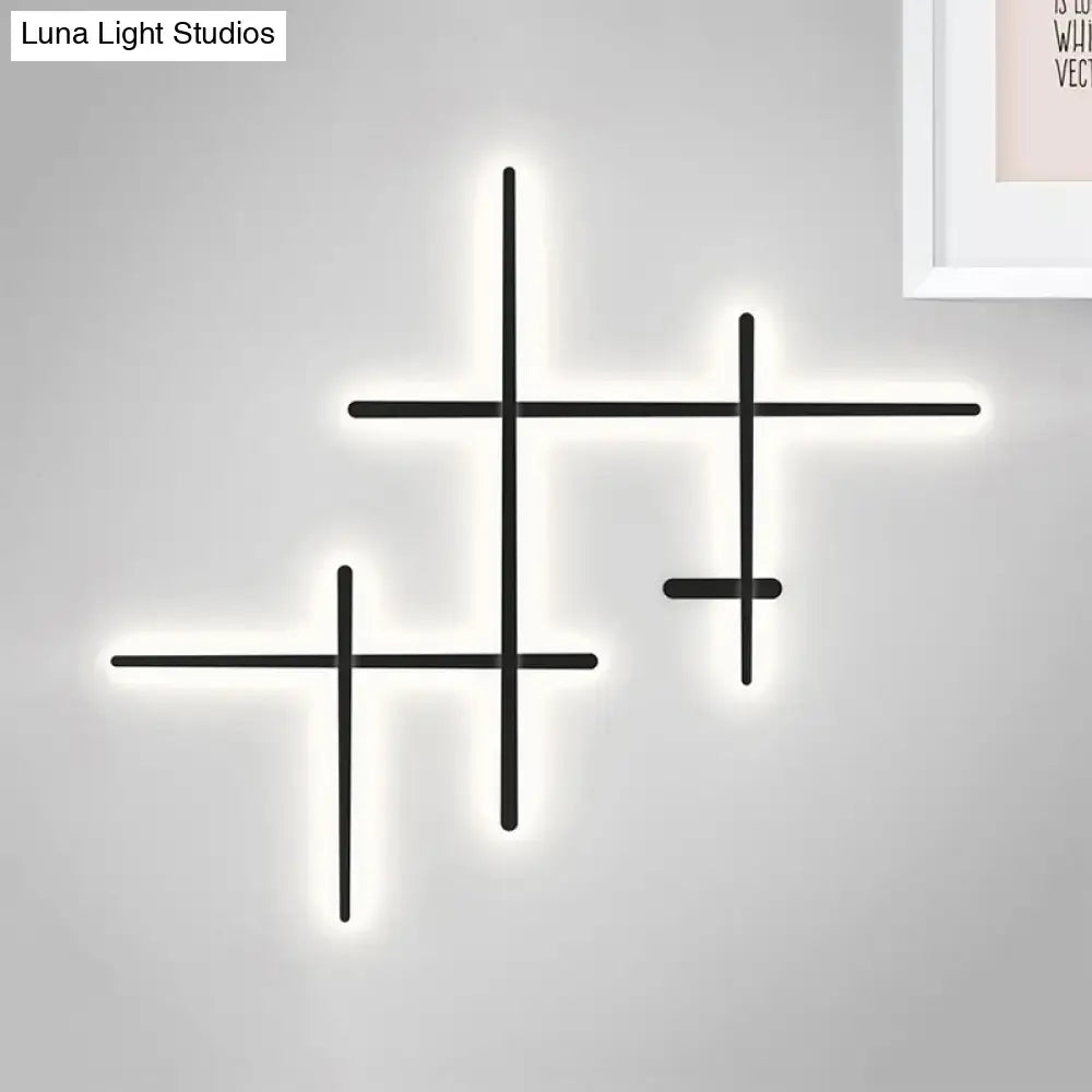 Modern black cross-shaped wall light with glowing white led bulb included and compatible bulb base for living room use