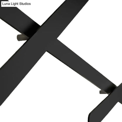 Modern black wall light with x-shaped matte metal leg and bulb included featuring a sleek bulb base design