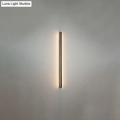 Minimalist modern black linear flush mount wall sconce with an elongated rectangular design emitting warm light