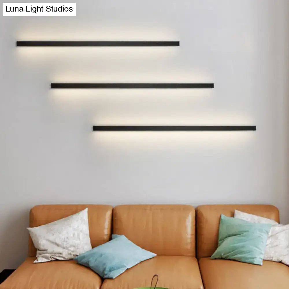 Three sleek black linear flush mount wall sconces with warm ambient lighting for modern hallway use