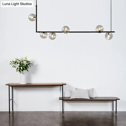 Modern black linear island pendant chandelier with five spherical glass shade globes for dining room lighting
