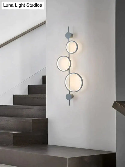 Modern black linear long led wall light with four frosted glass shades on a matte gray metal frame for living room use