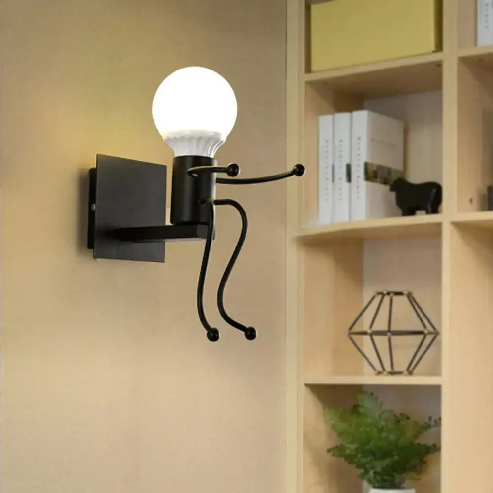 Modern black little man led wall light designed as a stick figure holding an illuminated bulb for bedroom use