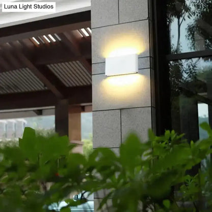 Modern black luna outdoor wall light with a white rectangular fixture emitting warm led glow for patio use