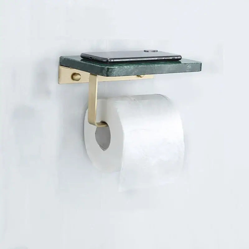 Modern black marble and gold toilet paper holder shelf with green marble surface holding toilet paper and smartphone