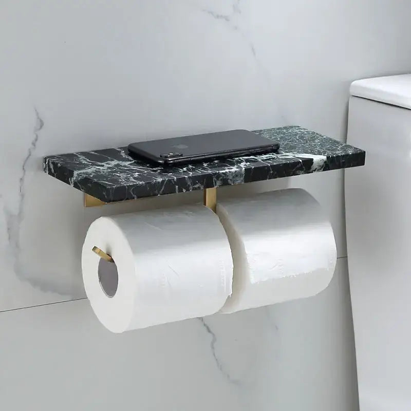 Modern black marble and gold toilet paper holder shelf with brackets holding two rolls of toilet paper and smartphone
