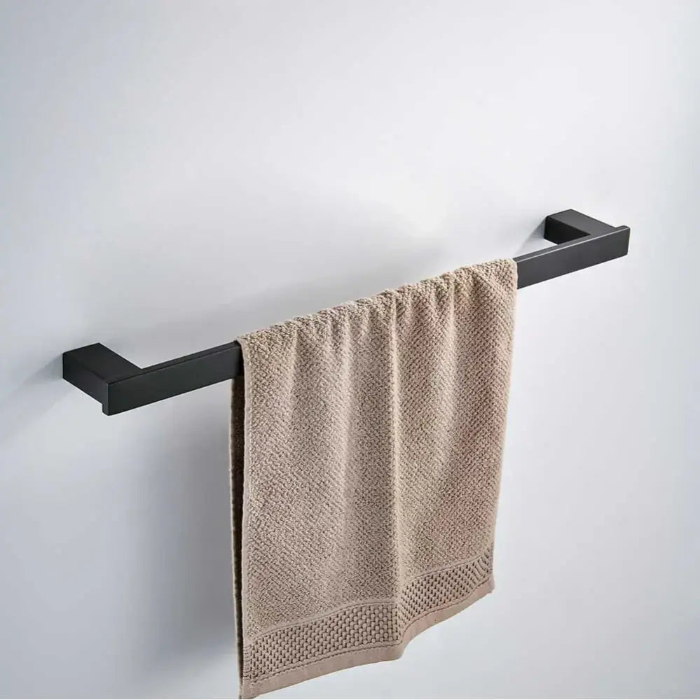 A beige textured towel hangs on a sleek decorbites black matte hardware set towel rack in black matte bathroom decor