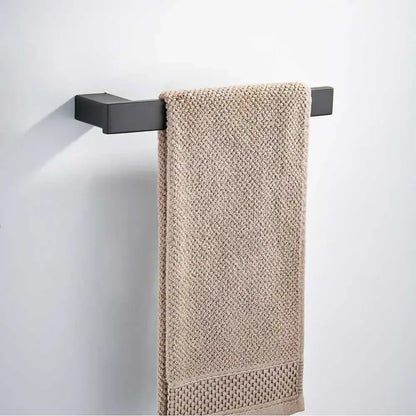 Beige textured towel hanging from a matte black rectangular bar in a decorbites black matte hardware set for bathroom decor