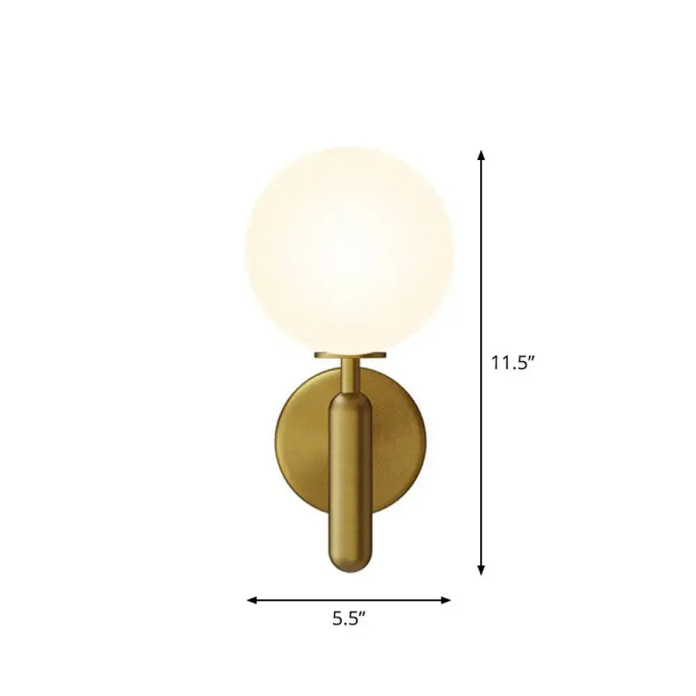 Brass-finished black gold wall sconce with frosted glass globe for modern stairs lighting