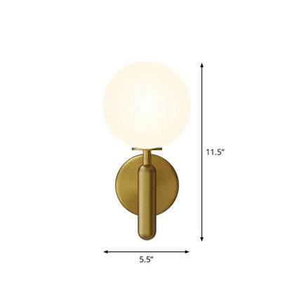Brass-finished black gold wall sconce with frosted glass globe for modern stairs lighting