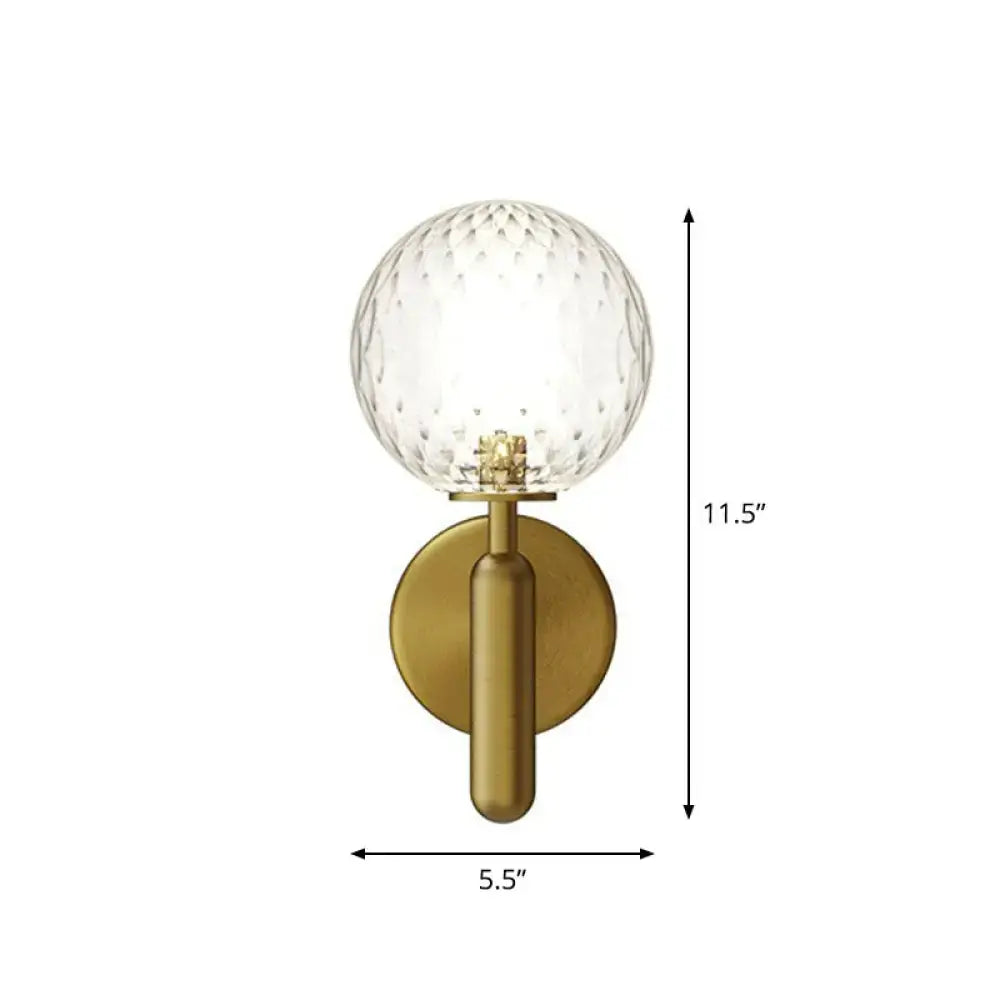 Brass-finished black gold wall sconce with clear faceted glass globe for modern stairs lighting