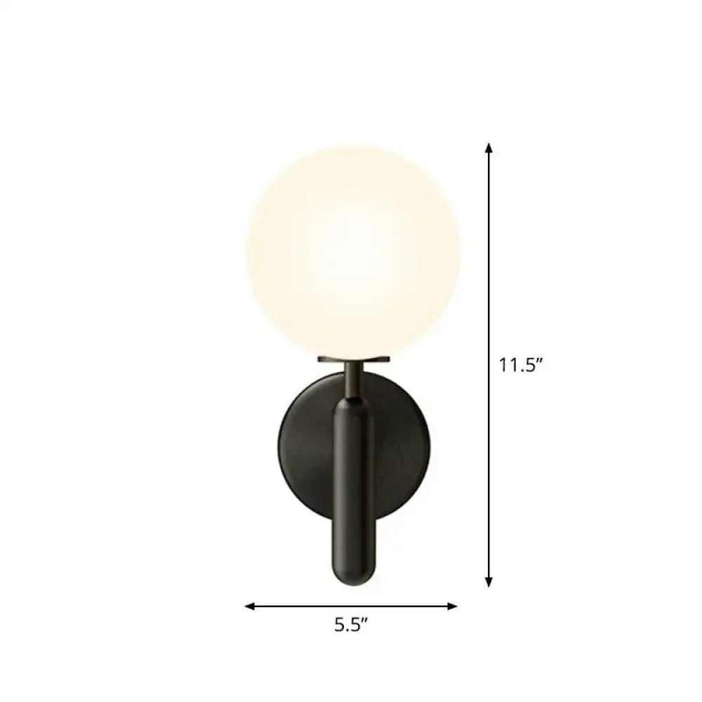 Modern black matte glass globe wall sconce with a black gold accent for stairs lighting featuring a frosted glass globe