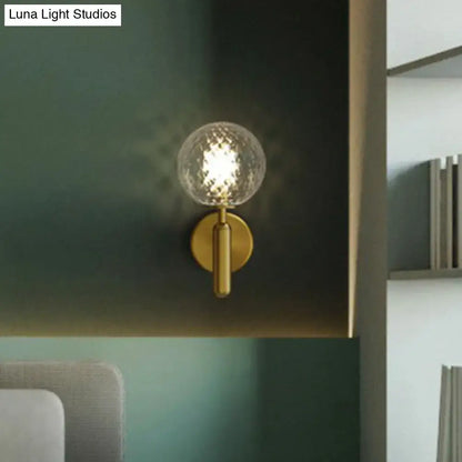 Modern black matte wall sconce with gold-toned faceted clear glass globe for stairs lighting