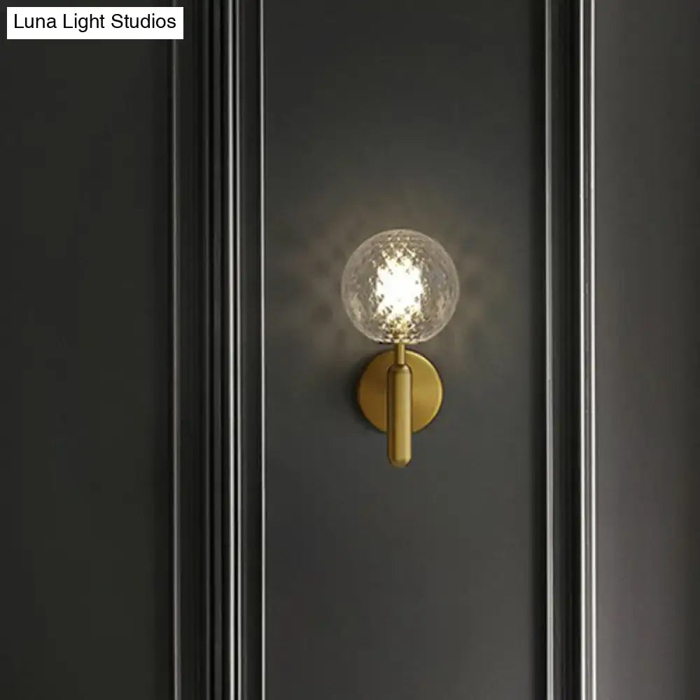 Modern black gold wall sconce with textured clear glass globe for stairs lighting and contemporary interiors