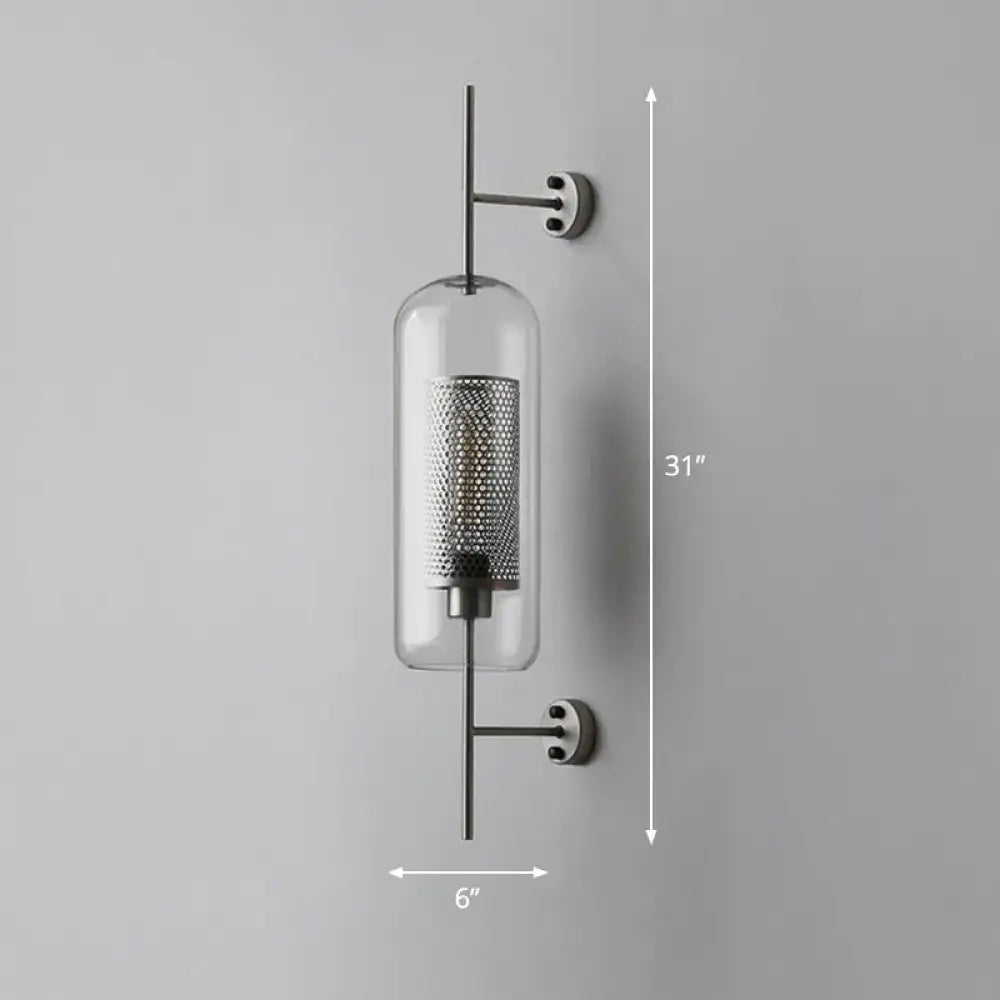 Modern black mesh wall mount lamp with clear glass cylinder and sleek metal arms for bedroom lighting