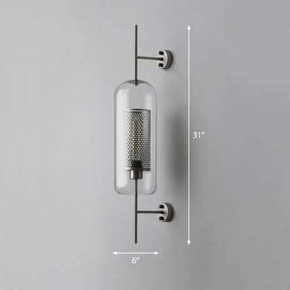 Modern black mesh wall mount lamp with clear glass cylinder and sleek metal arms for bedroom lighting