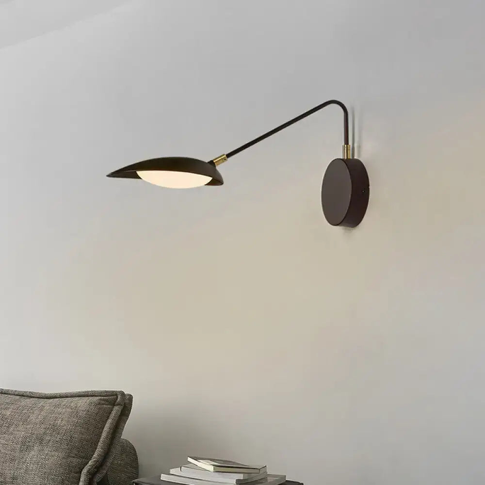 Modern black metal wall lamp with adjustable arm and leaf-shaped shade for bedroom reading use