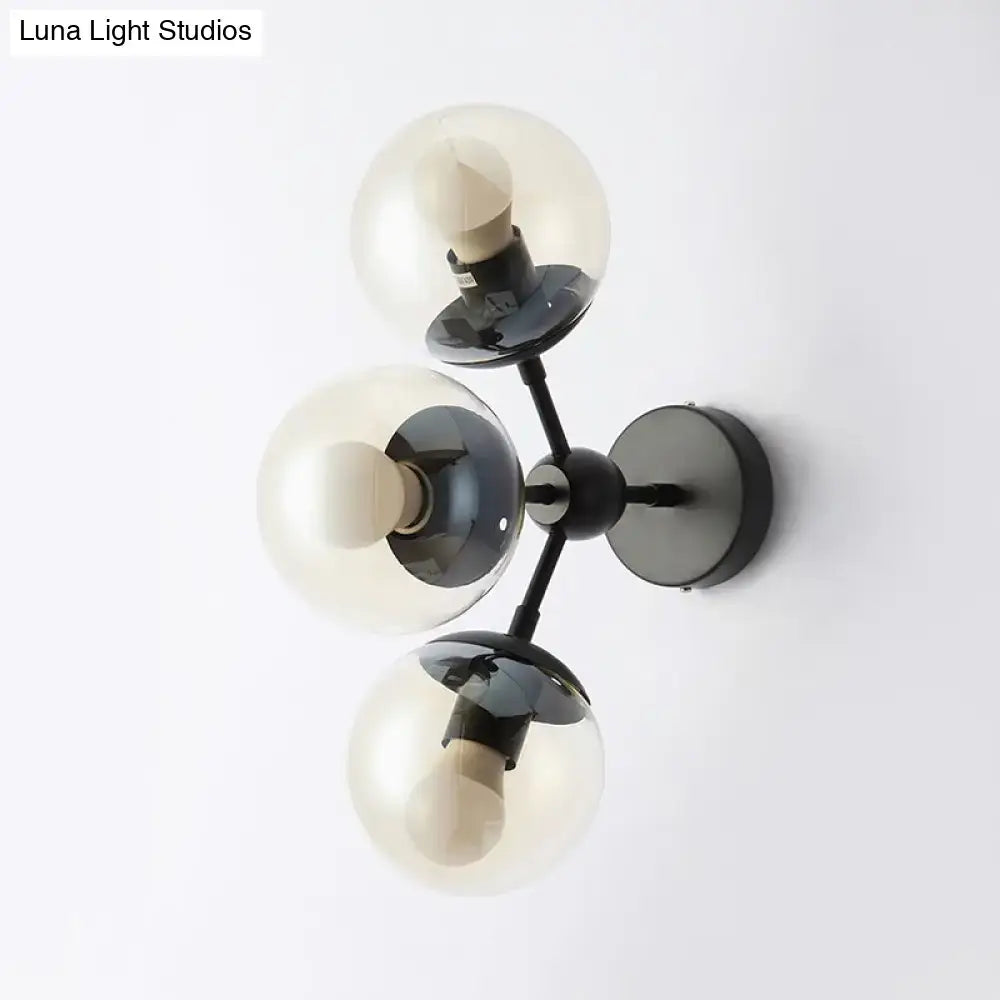 Modern black metal bathroom sconce with three frosted glass spheres for elegant wall lighting