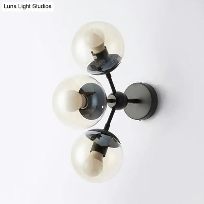 Modern black metal bathroom sconce with three frosted glass spheres for elegant wall lighting