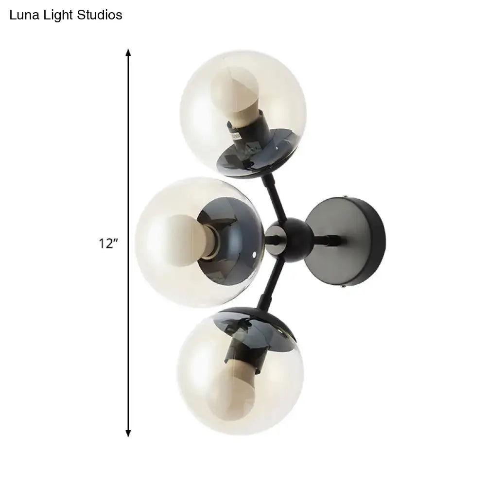 Modern black metal bathroom sconce featuring three clear glass spheres for elegant wall lighting