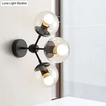 Modern black metal bathroom sconce with three clear glass spheres and globe shades for elegant lighting design