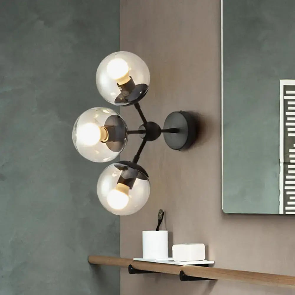 Modern black metal bathroom sconce featuring three clear glass spheres for elegant wall lighting