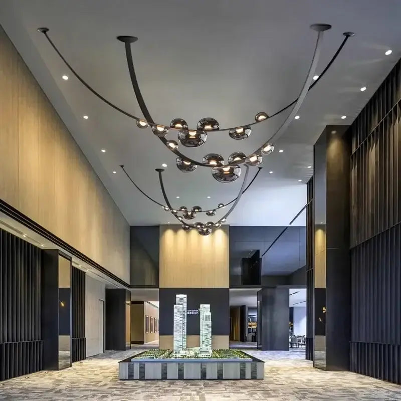 Modern black metal pendant light with curved arms and spherical glass globes ideal for decorbites designer leather loft decor