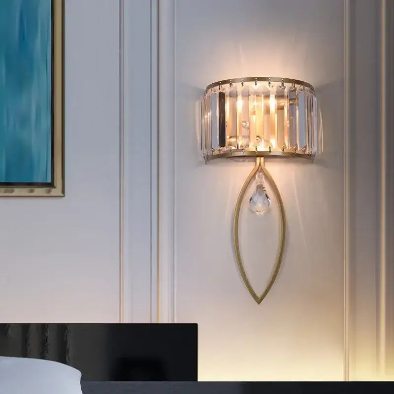 Gold-toned modern led wall lamp with black metal frame, cylindrical crystal cage, and teardrop pendant for living room