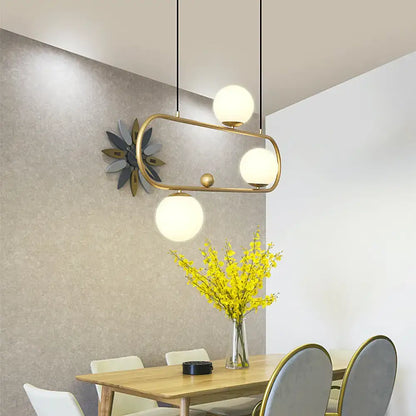Modern brass-framed metal oblong island light fixture with three frosted milk glass globes by decorbites