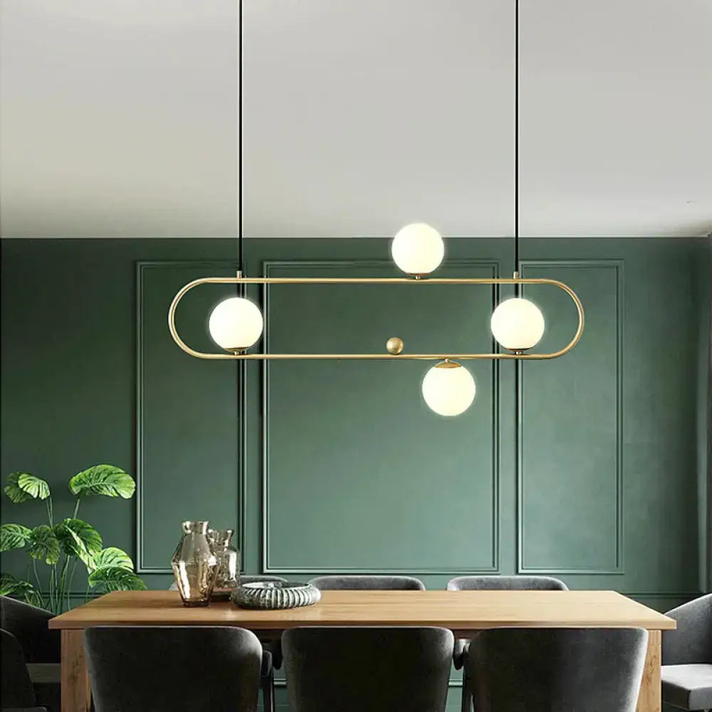 DecorBites minimalist metal oblong island light fixture with brass pendant and four frosted glass globe bulbs suspended by black cords