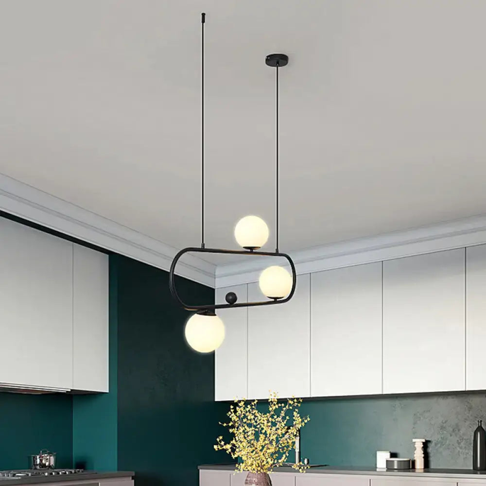 Modern black metal pendant island light fixture with three frosted milk glass globe shades by DecorBites™