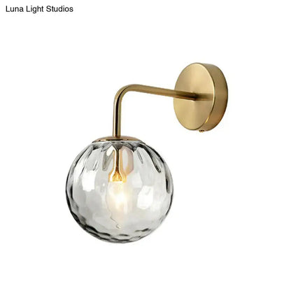 Modern black metal wall mount light with gold arm and clear faceted glass globe for bedroom wall mount lighting