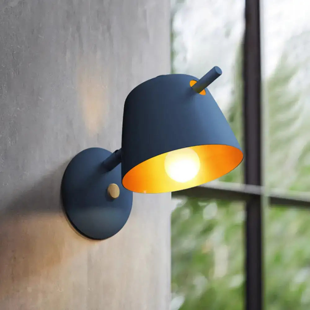 Modern black metal shade wall sconce with dark blue metal shade and warm orange interior for white blue bedroom light