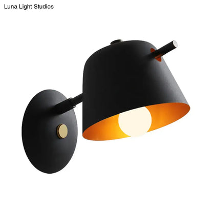 Modern black metal shade wall sconce with a matte finish, warm orange interior, and brass accent for white blue bedroom light