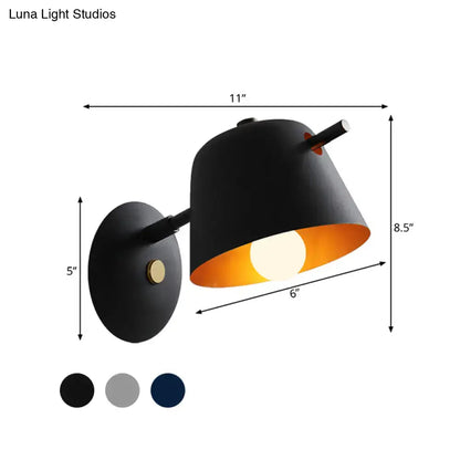 Modern black metal shade wall sconce with black matte finish brass details and warm interior for white blue bedroom light