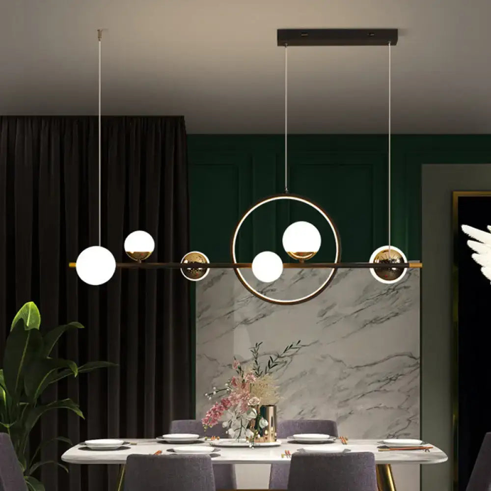 Modern black metal pendant light with spherical glass globes in an asymmetrical geometric pattern for dining room use