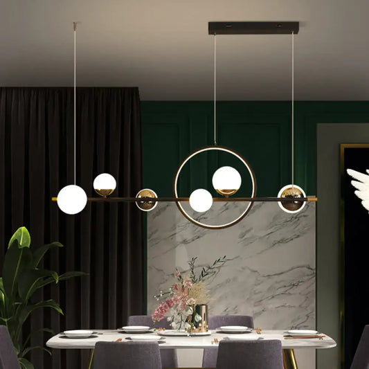 Modern black metal pendant light with spherical glass globes in an asymmetrical geometric pattern for dining room use