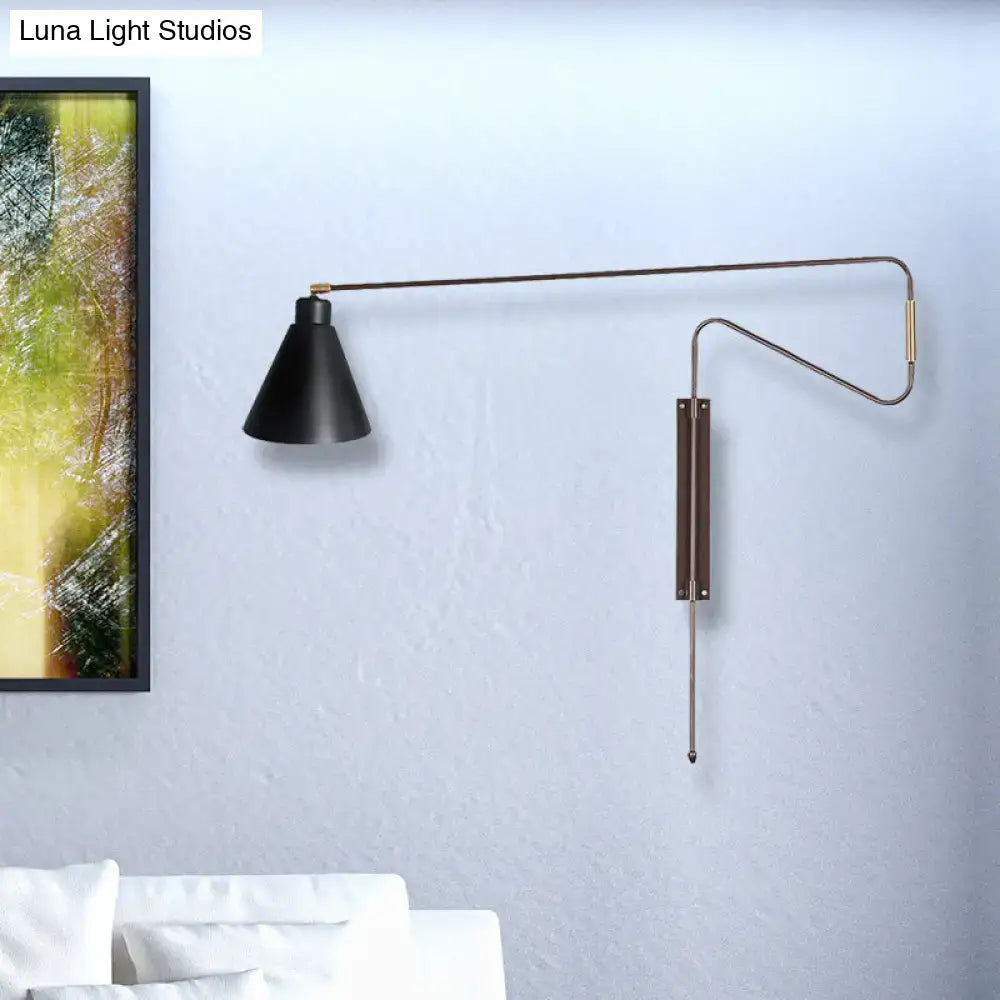 Modern black metal wall lamp with long articulated arm and brass accents designed as a sleek living room wall lamp