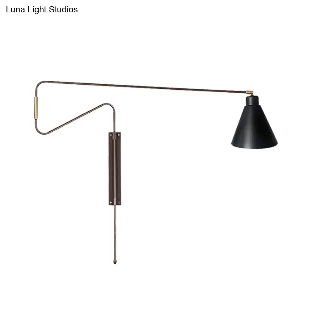 Modern black metal wall lamp with a conical shade, articulated arm, and black gold brass accents for living room use