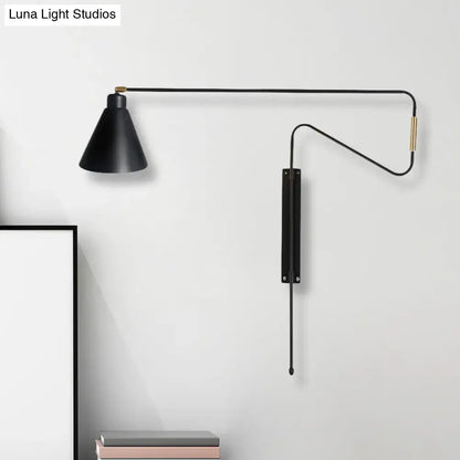 Modern black metal wall lamp with matte finish, brass accents, and articulated arm for living room use